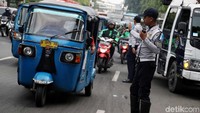 Petugas Dishub mengatur lalu lintas agar tak terjadi penumpukan kendaraan dan kemacetan selama proses sosialisasi penertiban parkir liar di Jalan Kramat Raya, Jakarta.