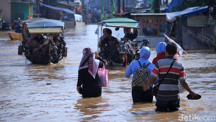 Wanita cantik, berhijab kuning bernama Anisa Rizkina mencuri perhatian banyak orang. Sebab ia nekat menerobos banjir dengan berjalan kaki di kabupaten Bandung.