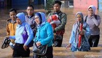 Beberapa warga lainnya ikut menerobos banjir dengan berjalan kaki.