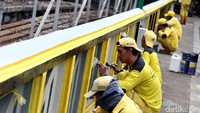 Petugas menyelesaikan detail pengecatan jembatan tersebut.