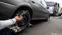 Ban mobil tersebut digemboskan sebagai sanksi karena parkir sembarangan.