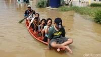 Sejumlah anak-anak ntampak duduk diatas perahu saat banjir di kawasan Kabupaten Bandung.