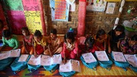 Anak-anak tersebut satu per satu mendapatkan buku untuk berlatih bahasa Burma.