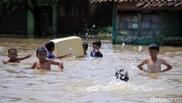 Banjir yang merendam sejumlah daerah di Kabupaten Bandung, Jawa Barat, dimanfaatkan oleh anak-anak untuk bermain air dan berenang. Mereka tampak senang sekali yah.