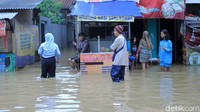 ebagian warga tetap bertahan di rumahnya yang terendam banjir.