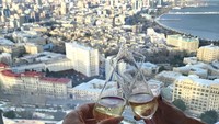 Dari ketinggian hotel, Sofia tampak menikmati wine berlatar pemandangan kota indah. Foto: Instagram@sofiasaravda