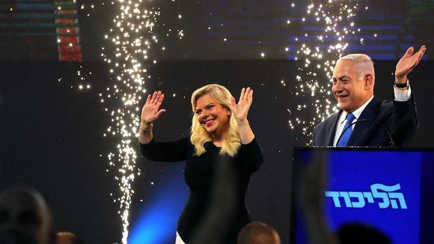 Perdana Menteri Israel Benjamin Netanyahu dan istrinya Sara bereaksi ketika mereka berdiri di atas panggung setelah pengumuman jajak pendapat keluar dalam pemilihan parlemen Israel di markas besar partai di Tel Aviv, Israel 10 April 2019. (REUTERS / Ammar Awad)