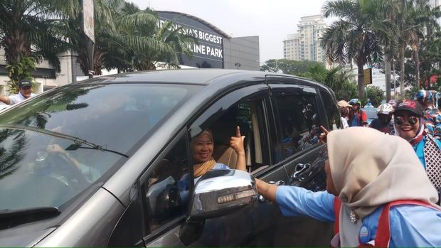 Massa membagikan brosur dan kipas ke pengendara.