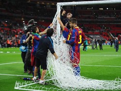 Gerard Pique dan David Villa memotong jaring gawang di Stadion Wembley sebagai tradisi mereka. (Foto: Clive Mason/Getty Images)