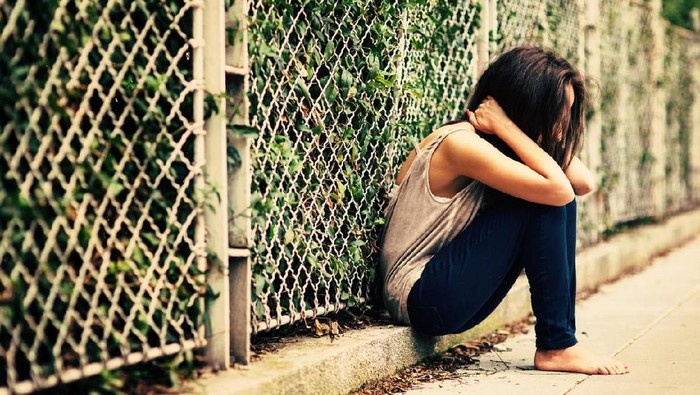 bullying depresi sedih Teenage girl sitting on a staircase outside feeling depressed