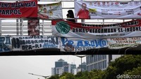 Warga melintas di dekat spanduk rakyat dukungan Prabowo-Sandiaga yang terpasang di salah satu JPO di Jakarta, Selasa (9/4/2019).