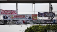 Spanduk tersebut bersanding dengan spanduk capres dan caleg lainnya.