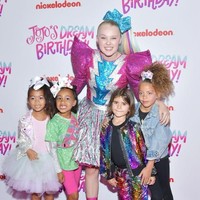 Begini gaya North saat tanpa disengaja difoto di belakang dua bocah tamu pesta Jojo. Memegang gelas berbentuk bola disko, North terlihat cukup menikmati pesta tersebut. Anak Kourtney Kardashian, Penelope, juga ikut menemani North. Foto: Getty Images