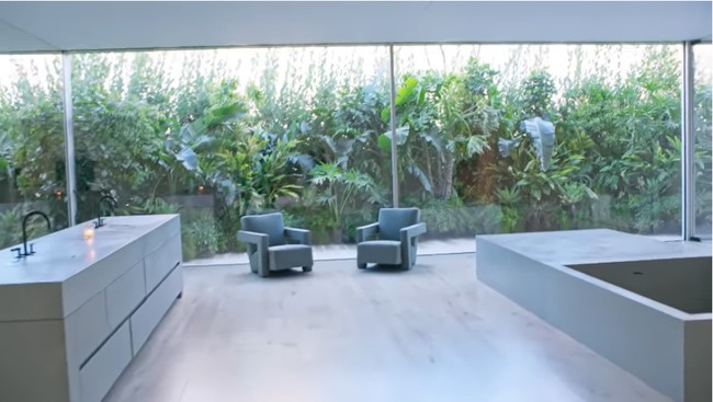 Ini area kamar mandi. Terdapat kursi abu-abu dan bath tub berbentuk kotak. Foto: Screenshot YouTube/Vogue