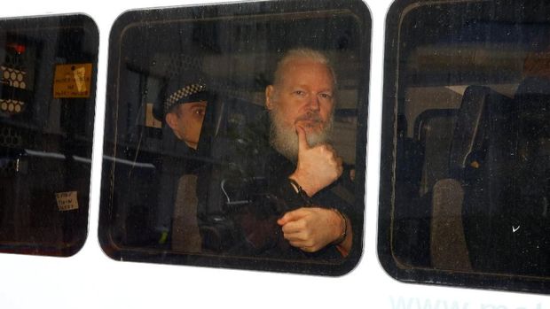 Assange mengacungkan jempol usai ditangkap di London