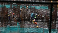 Para pekerja tampak sibuk melakukan pengecoran lantai. 