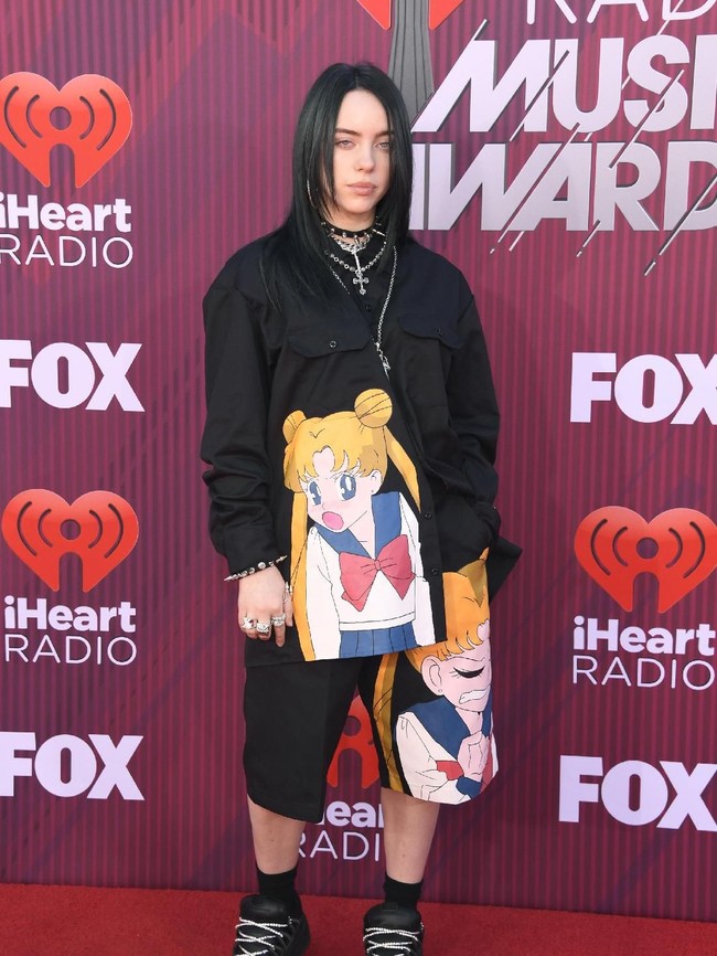 Ini penampilan Billie saat menyambangi penghargaan iHeart Radio Music Awards 2019 beberapa waktu lalu. Bersolek ala anak emo, Billie ditemani Sailor Moon yang menempel di baju dan celananya.  Foto: dok. Getty Images
