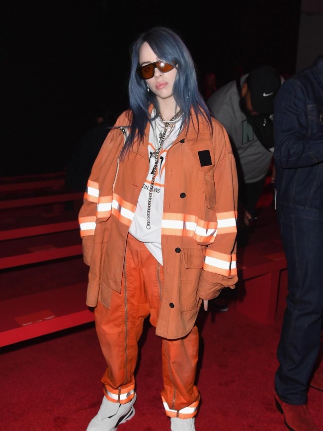 Pakaian oversized adalah salah satu busana andalan Billie. Seperti jaket bergaya pemadam kebaran dari Calvin Klein yang dipakainya saat menghadiri fashion show brand tersebut di New York Fashion Week tahun lalu.  Foto: dok. Getty Images