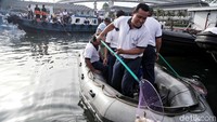 Para petugas TNI AL tampak semangat mengumpulkan sampah plastik yang terbawa arus hingga ke laut.