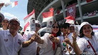 Massa pendukung Jokowi-Maruf Amin kompak mengenakan baju putih dengan membawa bendera merah-putih mini saat akan memasuki Gelora Bung Karno, Jakarta.