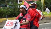 Massa pendukung membawa serta atribut partai politik koalisi pendukung Jokowi-Maruf Amin.