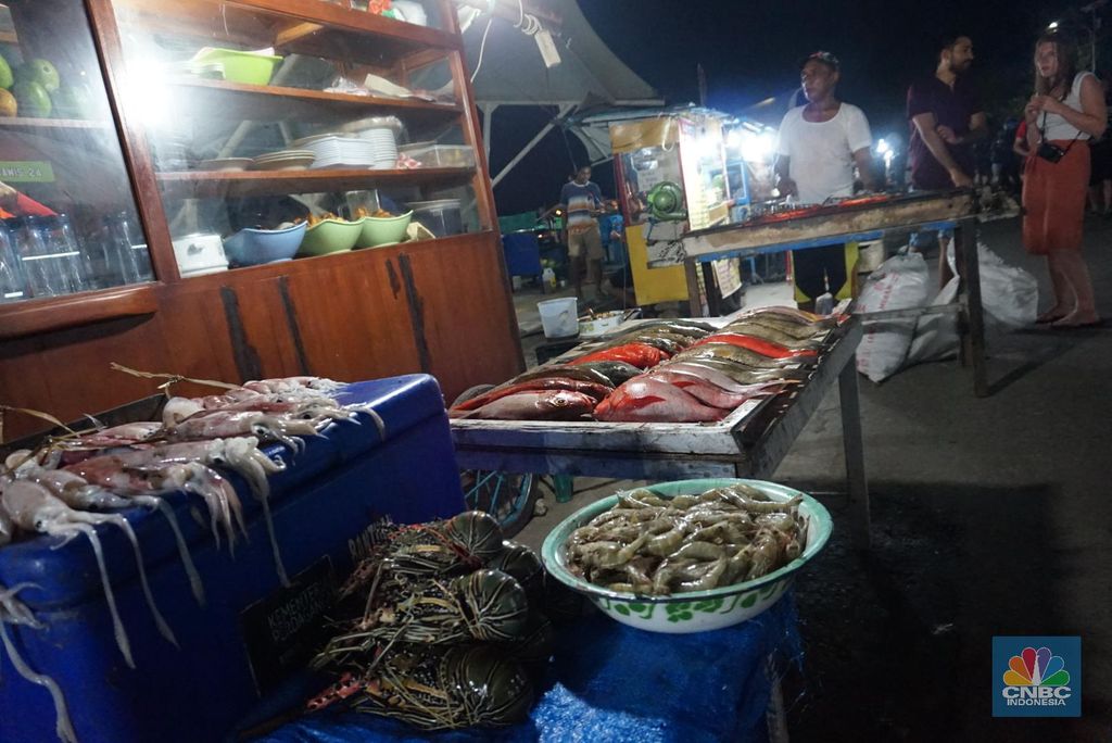 1. Jika Anda berkunjung ke Labuan Bajo, jangan lupa untuk berburu makanan laut segar di Kampung Ujung2. Di sana, Anda bisa menikmati berbagai macam makanan laut mulai dari ikan, udang, cumi, kepiting, hingga lobster. Harganya bervariasi dari Rp 40 ribu seekor hingga Rp 700 ribu/ekor tergantung beratnya.3. Lobster dan kepiting yang ditawarkan bobotnya tidak main main, untuk menikmatinya siapkan kocek yang agak tebal. Minimal Rp 500 ribu untuk lobster, tergantung kepandaian Anda dalam tawar menawar.4. Harga yang ditawarkan sudah termasuk dengan bumbu dan olahan yang Anda inginkan. Mulai dari dibakar, sup, asam manis, goreng, sesuai selera Anda. Rasa dagingnya dijamin berbeda, dan kesegarannya tidak diragukan5. Wisata kampung ujung kini juga tertata rapi berkat renovasi yang dilakukan oleh Kementerian PUPR pada 2017-2018 lalu. Kementerian PUPR menganggarkan Rp 40,35 miliar untuk membenahi beberapa titik wisata di Labuan Bajo. 6. Kampung Ujung paling enak dikunjungi saat malam hari, berbagai turis akan terlihat memadati lokasi mulai dari lokal hingga mancanegara.7. Selain makanan laut, Anda juga bisa menyicipi kuliner lainnya seperti buah-buahan, jus segar, dan es krim gelato rumahan.   (CNBC Indonesia/Gustidha Budiartie)