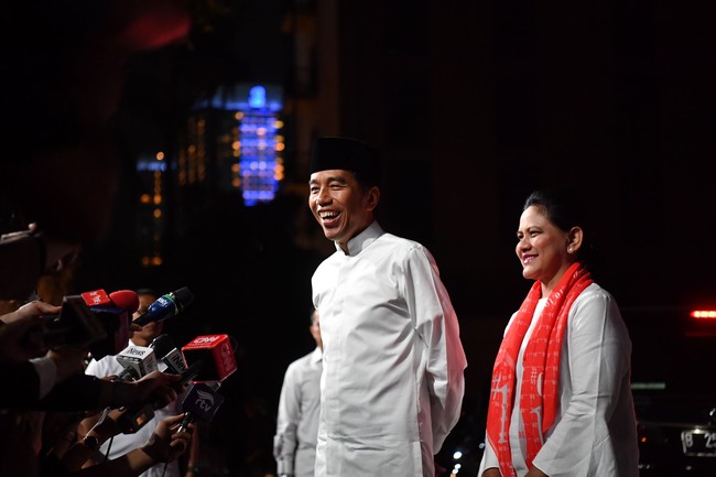 Busana putih seolah menjadi dresscode paslon nomor 1 saat kampanye maupun debat. Dan Iriana pun kembali memakai busana putih, di Debat Pilpres 2019 terakhir yang digelar di Hotel Sultan, Jakarta, Sabtu (13/03/2019). Lagi, ibu negara itu menggunakan syal 01 sebagai aksesori andalannya. Foto: Antara Foto/Rivan Awal Lingga
