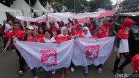 Pendukung membawa serta sejumlah atribut partai politik koalisi pendukung Jokowi-Maruf Amin di kawasan Medan Merdeka Barat, Jakarta.