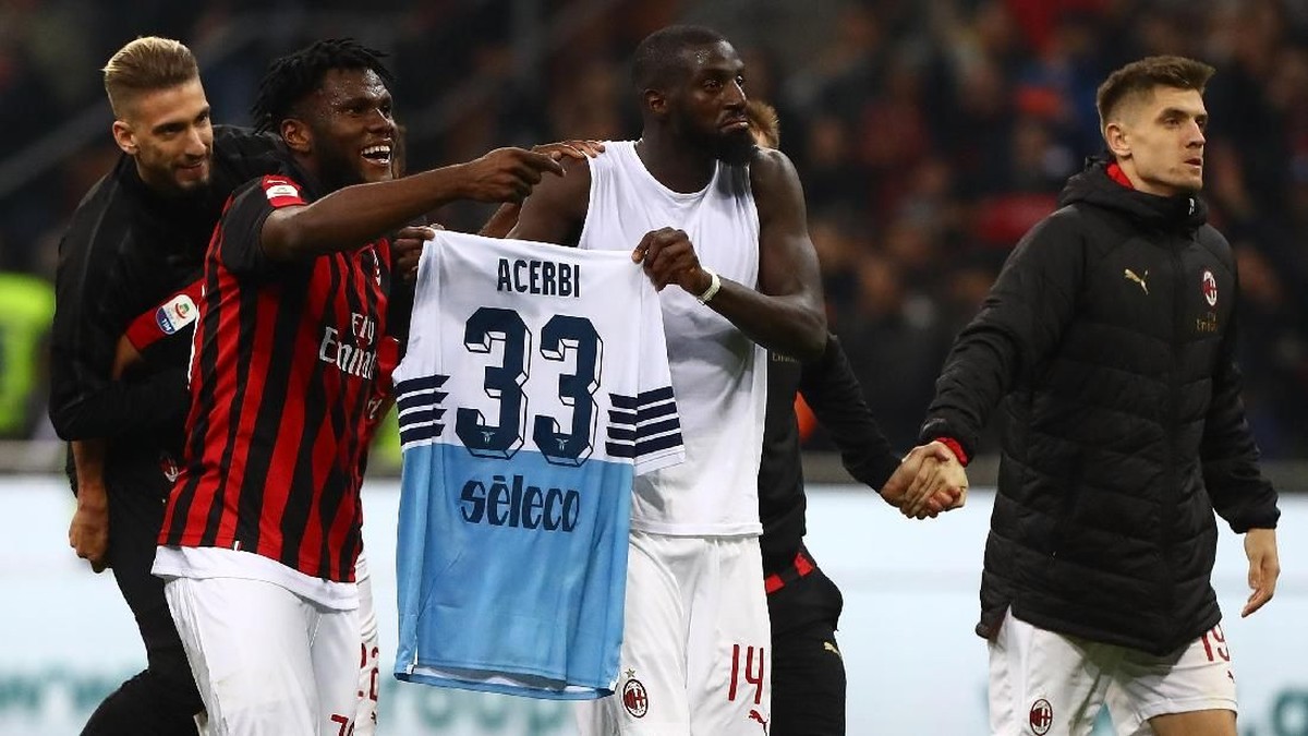 Franck Kessie dan Tiemoue Bakayoko membentangkan jersey pemain Lazio usai AC Milan menang 1-0 akhir pekan lalu. (Foto: Marco Luzzani/Getty Images)