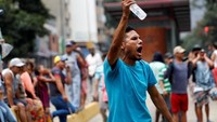 Seorang demonstran memberi isyarat pada protes terhadap pemerintah Venezuela.