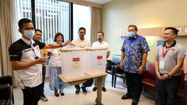 Petugas TPS PPLN Singapura memasukan surat suara yang dicoblos Ani di kotak suara.