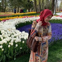 Ayu tampak berbeda saat mengenakan dress bermotif etnik dipadukan dengan hijab warna merah. Gaya hijab yang dipilihnya cukup sederhana dan cocok dipakai untuk traveling. Foto: Dok. Instagram Ayu Ting Ting