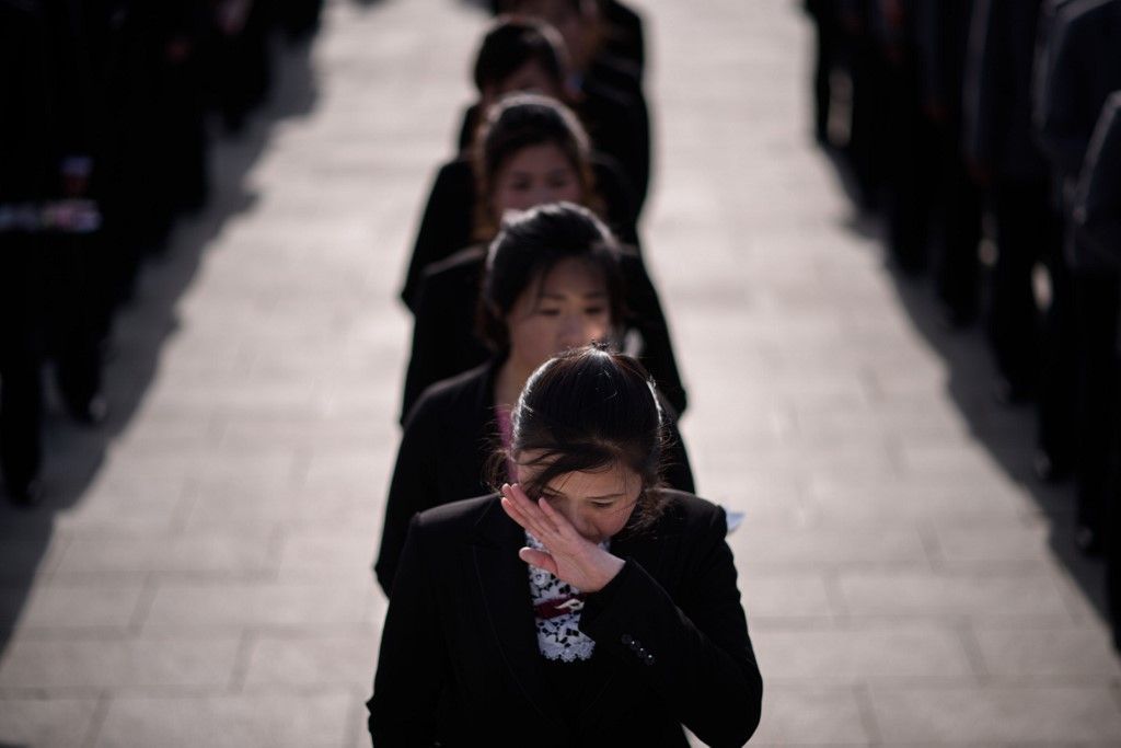 A woman talks on a mobile phone as Korean Peole's Army (KPA) soldiers arrive to pay their respects before the statues of late North Korean leaders Kim Il Sung and Kim Jong Il, as part of celebrations marking the anniversary of the birth of Kim Il Sung, known as the 'Day of the Sun', on Mansu hill in Pyongyang on April 15, 2019. (Photo by Ed JONES / AFP)