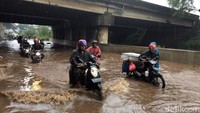 Sejumlah pengendara motor nampak menuntun kendaraan mereka saat terendam banjir di Jalan Kyai Haji Noer Ali, Bekasi, Senin (15/4/2019).