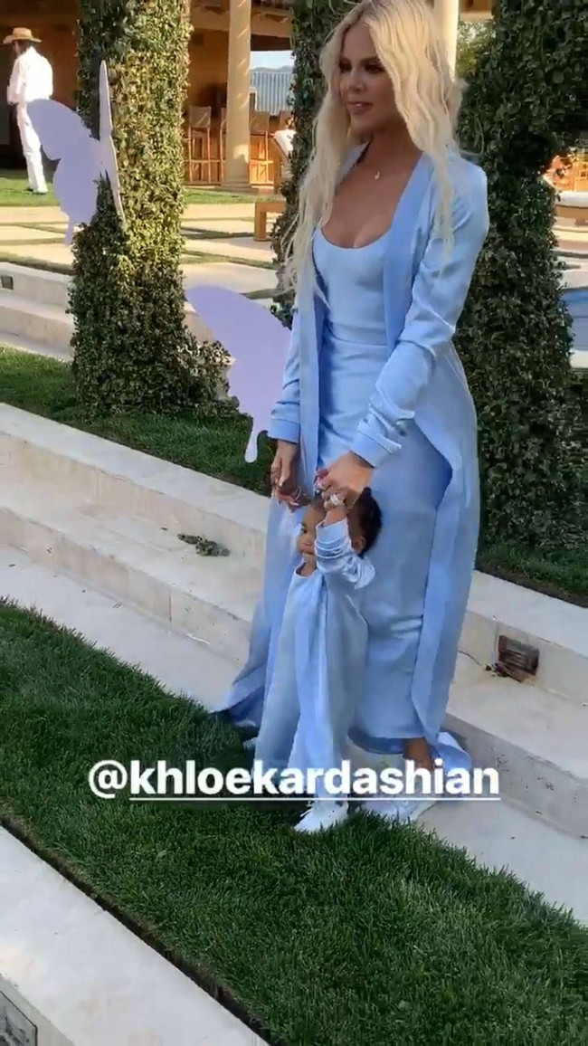 Khloe dan True memakai baju serupa, yaitu slip dress bernuansa biru, outerwear panjang dan sneakers putih. Foto: Dok. Instagram