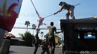 Sejumlah Satpol PP Kota Depok menurunkan Alat Peraga Kampanye (APK) di sepanjang Jalan Raya Sawangan, Depok, Senin (15/4/2019).