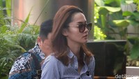 Siesa nampak mengenakan atasan berwarna biru dan celana berwarna putih serta berkacamata saat tiba di gedung KPK, Jakarta.