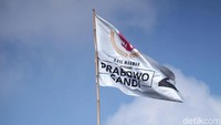 Anggota Satpol PP naik ke atas pohon untuk menurunkan bendera.