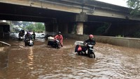 Sejumlah pengendara motor nekat menerobos banjir dengan menuntun motor mereka.