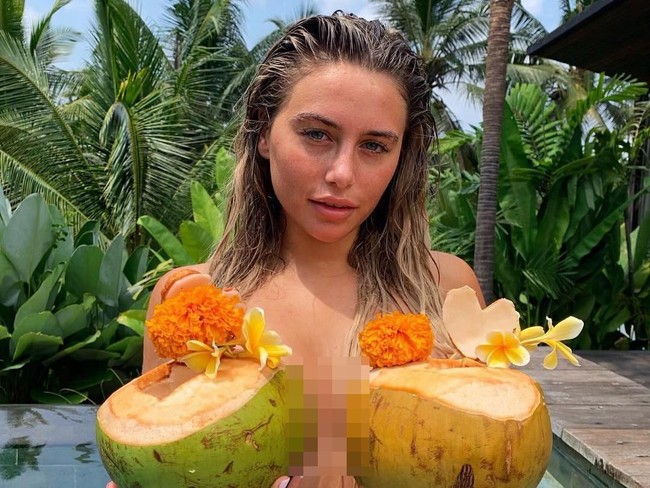 Ellie yang belum sepopuler Kim Kardashian mengunggah sederet foto liburannya di Bali. Salah satu penampilannya, dia berpose topless dengan menutupi dadanya memakai buah kelapa. Foto: Instagram @Brown.Elle