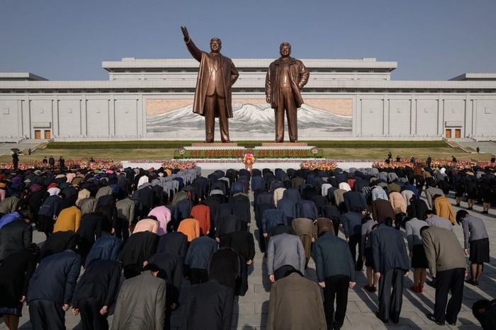 People bow as they pay their respects before the statues of late North Korean leaders Kim Il Sung and Kim Jong Il, as part of celebrations marking the anniversary of the birth of Kim Il Sung, known as the Day of the Sun, on Mansu hill in Pyongyang on April 15, 2019. (Photo by Ed JONES / AFP)