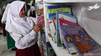 Seorang anak tengah memilih buku yang akan dibacanya.