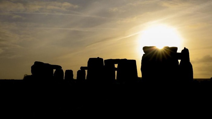 AMESBURY, ENGLAND - DECEMBER 22:  The sun rises over Stonehenge,  as people take part in a winter solstice ceremony at the ancient neolithic monument of Stonehenge near Amesbury on December 22, 2018 in Wiltshire, England. A large crowd gathered at the famous historic stone circle, a UNESCO listed ancient monument to celebrate the sunrise closest to the Winter Solstice, the shortest day of the year. The event is claimed to be more important in the pagan calendar than the summer solstice, because it marks the re-birth of the Sun for the New Year. (Photo by Matt Cardy/Getty Images)