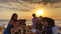 Berlibur ke Bali, Erika ngumpul bersama teman-temannya ditemani aneka minuman dingin hingga es kelapa, sambil melihat pemandangan matahari terbenam dengan hamparan laut lepas. Foto: Instagram @eri.carl