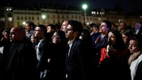 Warga kota Paris berkerumun di lokasi aman sambil menyaksikan upaya pemadaman yang terus dilakukan. Foto: REUTERS/Benoit Tessier