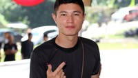Seorang pemilih berpose salam dua jari dengan jari telunjuk dan jempol yang telah dicelup ke tinta yang disediakan usai mencoblos.