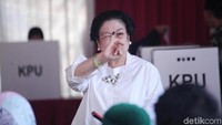 Megawati menunjukkan jari kelingking yang telah dicelupkan ke tinta tanda telah melakukan pencoblosan.