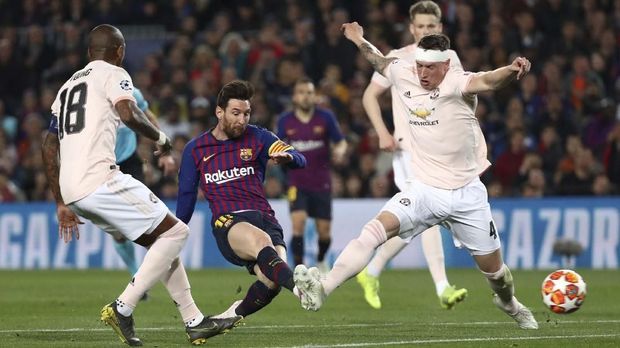 Phil Jones (kanan) dibuat kesulitan dengan pergerakan Lionel Messi.