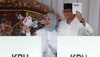 Sandiaga berpose memegang surat suara bersama sang Istri, Nur Asia Uno, usai mencoblos.