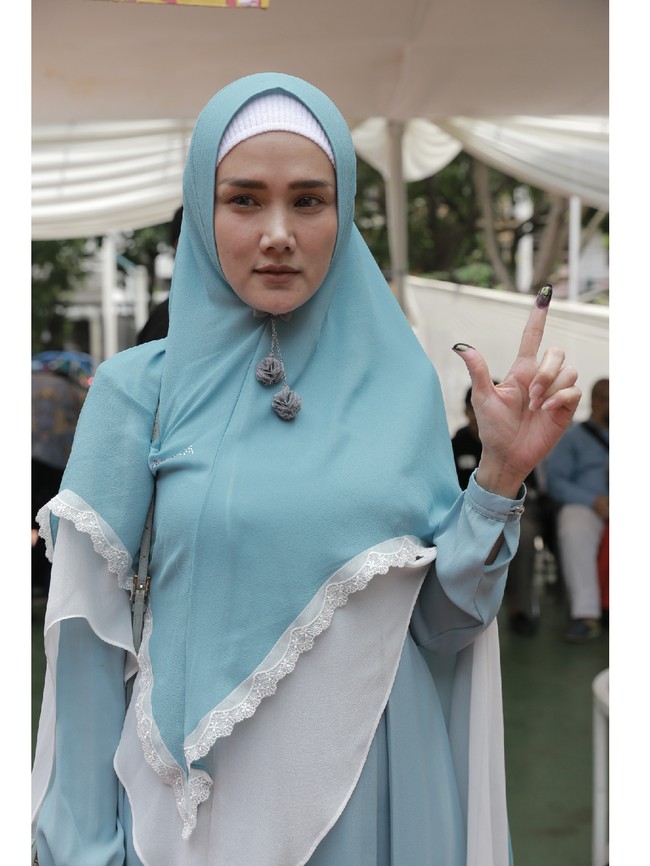Mulan Jameela tampil dengan hijab syari saat pencoblosan. Istri Ahmad Dhani itu tampil dengan busana serba biru.  Foto: Hanif Hawari